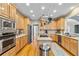 Well-lit kitchen with light wood cabinets, stainless steel appliances, and gas cooktop on island at 1142 Hidden Spirit Trl, Lawrenceville, GA 30045