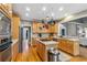 Spacious kitchen boasts stainless appliances, light wood cabinetry, pot rack, and hardwood floors at 1142 Hidden Spirit Trl, Lawrenceville, GA 30045