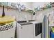 Functional laundry room with washer, dryer, storage shelves, and ironing board at 1142 Hidden Spirit Trl, Lawrenceville, GA 30045