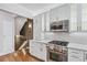 Charming kitchen with white cabinetry, stainless appliances and brick backsplash at 53 Paces West Nw Dr, Atlanta, GA 30327