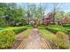 Beautifully landscaped walkway features trimmed hedges and a brick pathway, adding charm and elegance to the property at 53 Paces West Nw Dr, Atlanta, GA 30327