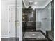 Walk-in shower with granite tiles, glass doors, and brass shower fixtures at 53 Paces West Nw Dr, Atlanta, GA 30327
