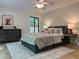 This bedroom offers a ceiling fan, dresser, bedside tables and scenic views through a large window at 541 Earlvine Nw Way, Kennesaw, GA 30152