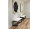 Well-lit hallway with hardwood flooring, white benches, and modern art adorning the walls at 541 Earlvine Nw Way, Kennesaw, GA 30152