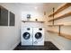 Well-organized laundry room with modern washer and dryer units and custom shelving at 541 Earlvine Nw Way, Kennesaw, GA 30152
