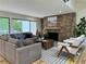 Cozy living room with stone fireplace, sectional sofa, and large windows at 541 Earlvine Nw Way, Kennesaw, GA 30152