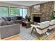 Cozy living room with stone fireplace, sectional sofa, and large windows at 541 Earlvine Nw Way, Kennesaw, GA 30152