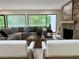 Cozy living room with a stone fireplace, large windows overlooking lush greenery, and comfortable seating at 541 Earlvine Nw Way, Kennesaw, GA 30152