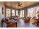 Bright sunroom with large windows, ceiling fan and comfortable seating area with nature views at 622 Goldpoint Trce, Woodstock, GA 30189