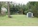 Large, grassy backyard with a storage shed and shady trees at 1130 Ridge Ave, Stone Mountain, GA 30083