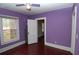 Bedroom with purple walls, hardwood floors, ceiling fan, and natural light from the windows at 1130 Ridge Ave, Stone Mountain, GA 30083