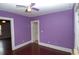 This bedroom has purple walls, hardwood floors and view to another room at 1130 Ridge Ave, Stone Mountain, GA 30083