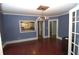 Dining area boasts original hardwood floors, blue walls, and a decorative ceiling fixture with modern chandelier at 1130 Ridge Ave, Stone Mountain, GA 30083