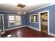 Dining room features hardwood floors, blue walls, and a unique window looking into the kitchen at 1130 Ridge Ave, Stone Mountain, GA 30083