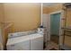 Cozy laundry area featuring a washer, dryer, and a traditional water heater at 1130 Ridge Ave, Stone Mountain, GA 30083