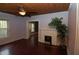 Living room with wooden floors, ceiling fan, fireplace, and natural light, creating a comfortable living space at 1130 Ridge Ave, Stone Mountain, GA 30083