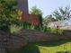 Landscaped backyard featuring a stone retaining wall, a wood fence, and colorful flower accents at 139 Stargaze Rdg, Canton, GA 30114