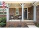 Inviting front porch with brick accents, cozy seating, and a welcoming entrance at 139 Stargaze Rdg, Canton, GA 30114