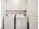 Clean laundry room with new, white front-load washer and dryer machines at 6347 Towhee Way, Morrow, GA 30260