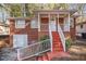 Charming brick home featuring a cozy front porch with red stairs and white railing at 165 Holly Nw Rd, Atlanta, GA 30314