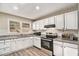 Well-lit kitchen featuring white cabinets, granite countertops, and stainless steel appliances at 165 Holly Nw Rd, Atlanta, GA 30314