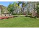 A sprawling backyard featuring a wooden deck and lush lawn with landscaped borders and mature trees at 1665 Millhouse Lndg, Marietta, GA 30066