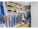 Organized walk-in closet featuring adjustable shelves, hanging rods, and clear garment bags for optimal storage at 1665 Millhouse Lndg, Marietta, GA 30066