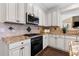 Updated kitchen features granite counters, white cabinets, stainless appliances, and a stylish backsplash at 1665 Millhouse Lndg, Marietta, GA 30066