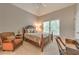 Cozy bedroom features neutral carpet, ceiling fan, a large window, and a chair at 1956 Grace Arbor Ne Ct, Atlanta, GA 30329
