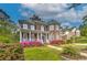 Elegant two-story brick home with a covered porch and vibrant landscaping showcasing pink flowers at 1956 Grace Arbor Ne Ct, Atlanta, GA 30329