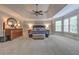 This is a main bedroom with a tray ceiling, a ceiling fan, several windows, and plush carpeting at 1956 Grace Arbor Ne Ct, Atlanta, GA 30329