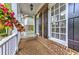 Cozy front porch with brick flooring, white railings, and hanging flower baskets at 1956 Grace Arbor Ne Ct, Atlanta, GA 30329