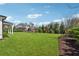 Well-manicured backyard with lush green grass and mature landscaping and clear skies at 214 Leland Way, Woodstock, GA 30188