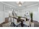 Formal dining room with wainscoting, elegant lighting, and hardwood floors adjacent to the stairs at 214 Leland Way, Woodstock, GA 30188