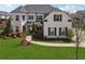 Beautiful two-story white brick home with black shutters and a well-manicured lawn at 214 Leland Way, Woodstock, GA 30188