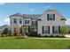 Charming two-story home with white brick, black shutters, and lush green lawn under blue sky at 214 Leland Way, Woodstock, GA 30188