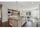 Bright kitchen with a large island, stainless appliances, and open access to the living area at 214 Leland Way, Woodstock, GA 30188