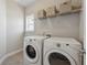 Laundry room with front load washer and dryer set and wire shelving with wicker baskets at 214 Leland Way, Woodstock, GA 30188