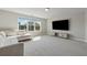 Spacious living room with a large window, a plush sectional sofa, and a big screen TV at 214 Leland Way, Woodstock, GA 30188