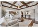 Open-concept living room with coffered ceiling and hardwood floors leading to the kitchen at 214 Leland Way, Woodstock, GA 30188