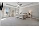 Spacious main bedroom with tray ceiling, plush carpeting, and large windows at 214 Leland Way, Woodstock, GA 30188