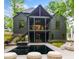 Stunning back exterior featuring a dark exterior, covered patio, pool, lounge seating, and elegant landscaping at 402 Chattahoochee St, Roswell, GA 30075