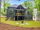 Beautiful backyard with a spacious covered patio and a fire pit area surrounded by lush greenery at 402 Chattahoochee St, Roswell, GA 30075