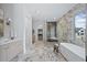 Luxurious bathroom with marble flooring, standalone tub, and a glass-enclosed shower at 402 Chattahoochee St, Roswell, GA 30075