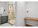 Modern bathroom featuring walk in shower, wood shelves, grey vanity, black hardware and wood shelving at 402 Chattahoochee St, Roswell, GA 30075