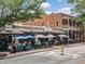 Outdoor dining with striped umbrellas at Zest, surrounded by vibrant street life at 402 Chattahoochee St, Roswell, GA 30075