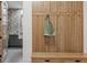 Entryway with bench and hooks, leading to laundry room with floral wallpaper at 402 Chattahoochee St, Roswell, GA 30075