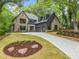 Beautiful home with manicured front lawn and elegant landscaping, featuring a long driveway and attached garage at 402 Chattahoochee St, Roswell, GA 30075