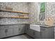 Charming laundry room boasts gray cabinets, floating shelves, and white farmhouse sink with brass fixtures at 402 Chattahoochee St, Roswell, GA 30075