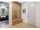 Bright mudroom features wood accent wall with hooks, storage bench, light hardwood floors, and an exterior door at 402 Chattahoochee St, Roswell, GA 30075